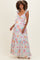 woman wearing a pastel floral print maternity maxi dress with ruffle straps and a baby bump visible