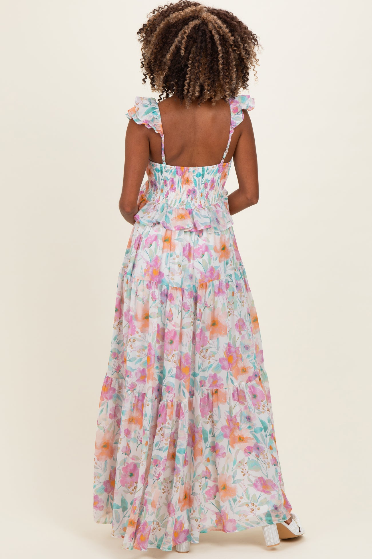 woman wearing a floral maxi maternity dress with ruffle straps, showing the back and flowy silhouette
