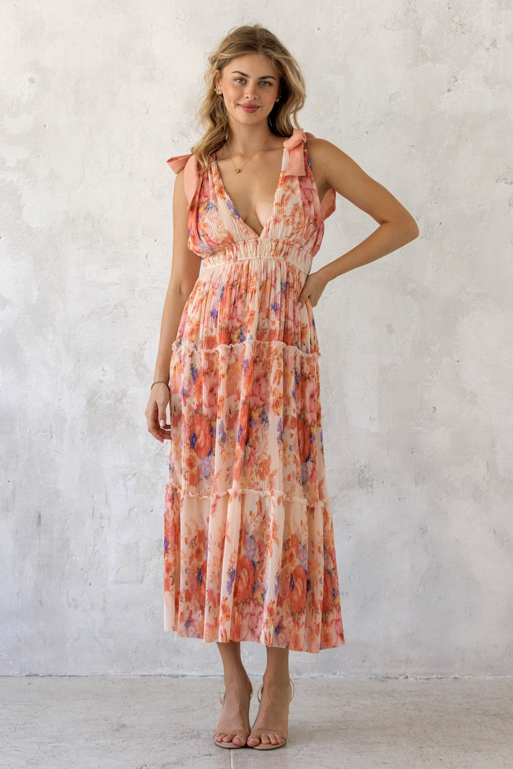 woman wearing a floral print maxi dress with tiered ruffles and tie shoulder straps