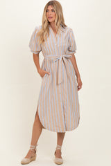 woman wearing a beige striped midi dress with puff sleeves, a tied waist, and side pockets