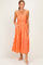 woman wearing an orange and white checked maxi dress with adjustable straps and pockets