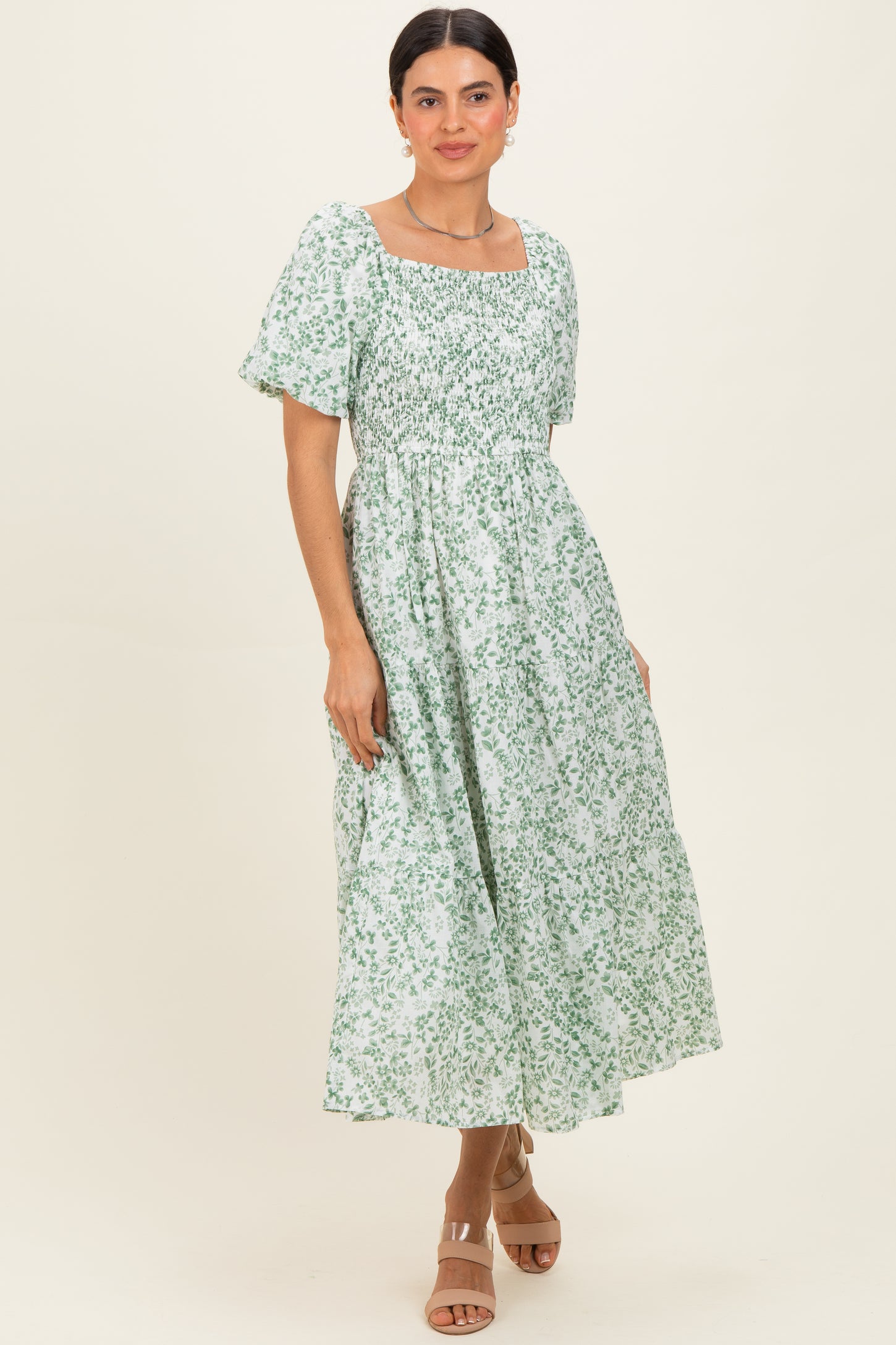 woman wearing a green floral midi dress with short puff sleeves and a square neckline