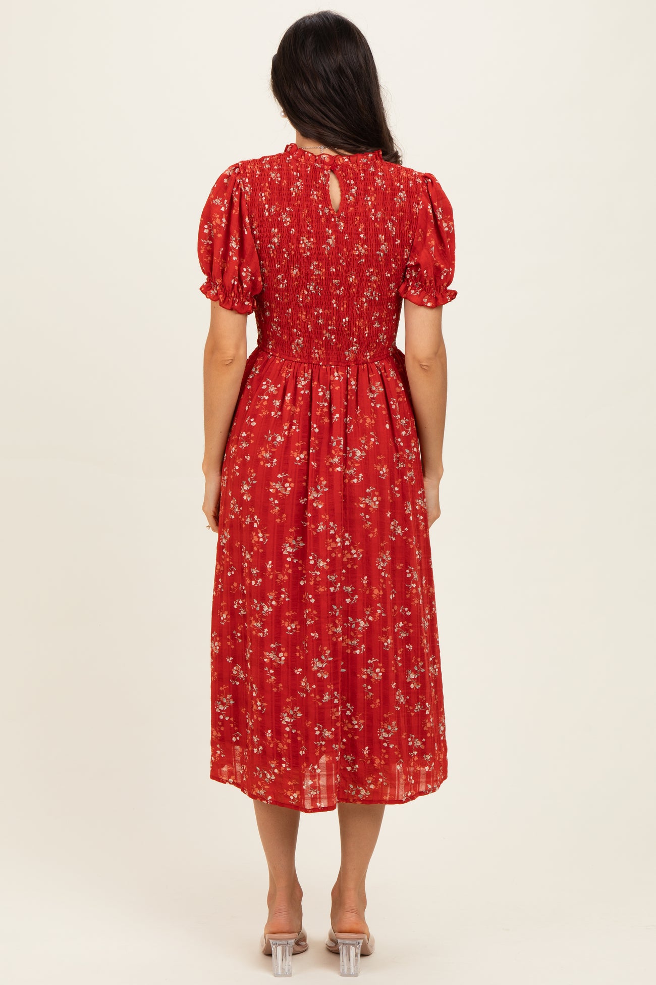 woman wearing a red floral midi dress with short puff sleeves and a keyhole back detail