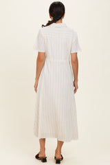 woman wearing a long white striped dress with short sleeves and a cinched waist, seen from the back