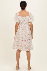 woman wearing a floral print short sleeve midi dress with a square neckline and gathered waist, seen from the back