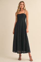 woman wearing a black lace maxi dress with thin straps and a fitted bodice
