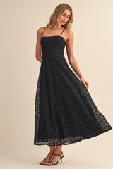 woman wearing a black lace maxi dress with spaghetti straps and a flowy skirt