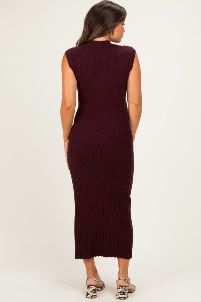 woman wearing a dark burgundy sleeveless ribbed maternity dress, showing a fitted silhouette from the back