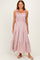 woman wearing a pink maxi dress with ruffled straps and a smocked bodice