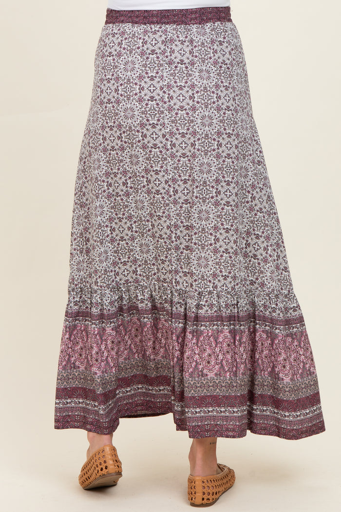 woman wearing a patterned maxi maternity skirt with a tiered hem and comfortable elastic waistband