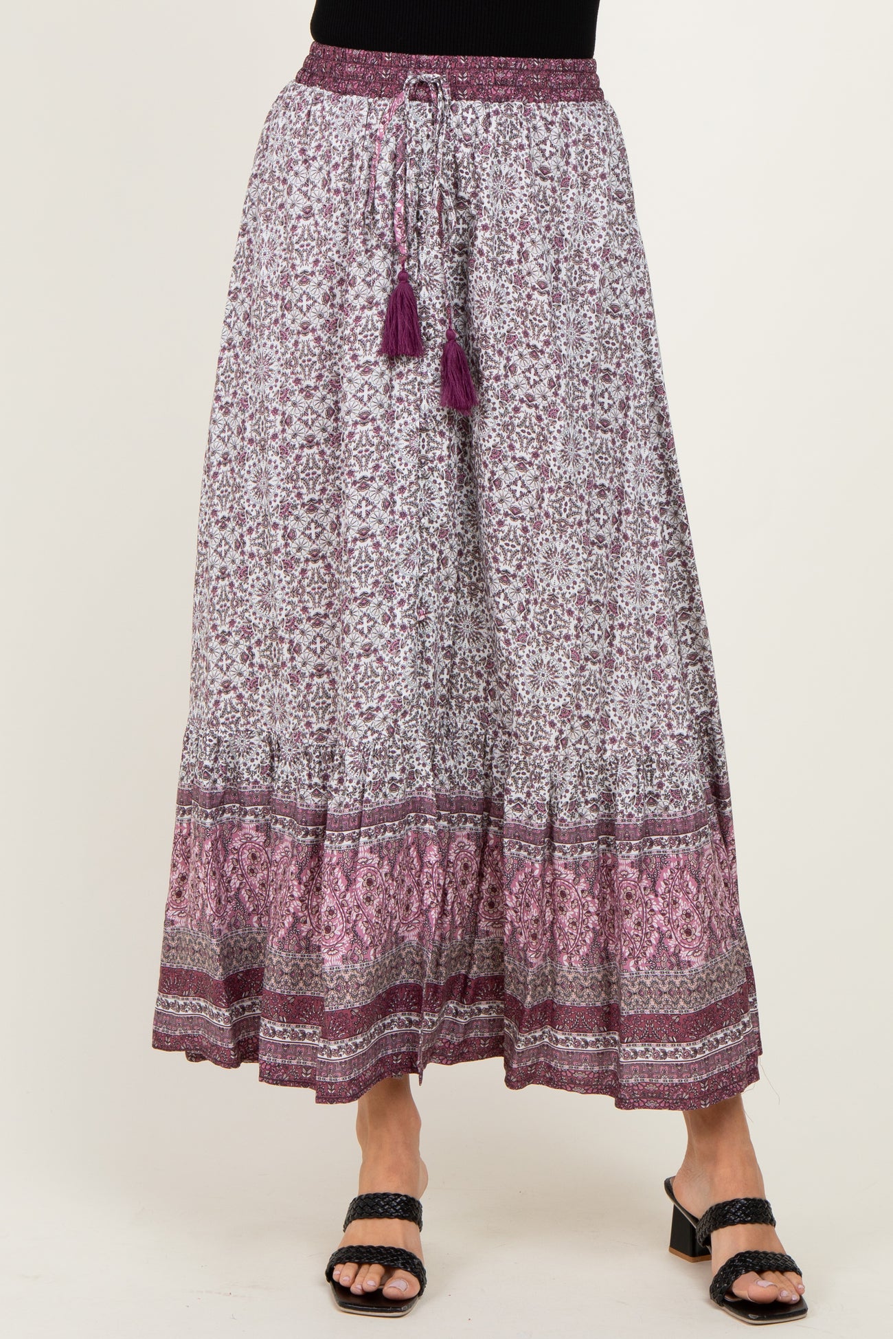 woman wearing a purple and white patterned maxi skirt with tassel drawstring and layered hemline