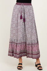 woman wearing a purple and white patterned maxi skirt with tassel drawstring and layered hemline