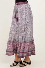 woman wearing a purple and white floral print maxi skirt with a tiered hem and tassel details
