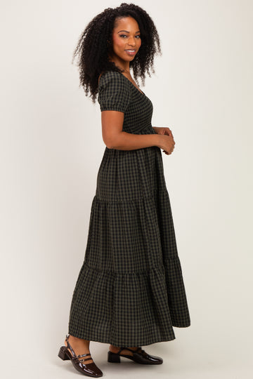 woman wearing a dark green and black checkered maxi dress with short sleeves and tiered skirt, standing sideways