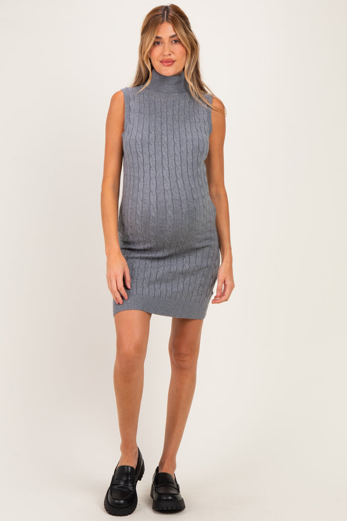 woman wearing a gray sleeveless maternity dress with a high neck and ribbed texture, showcasing her baby bump