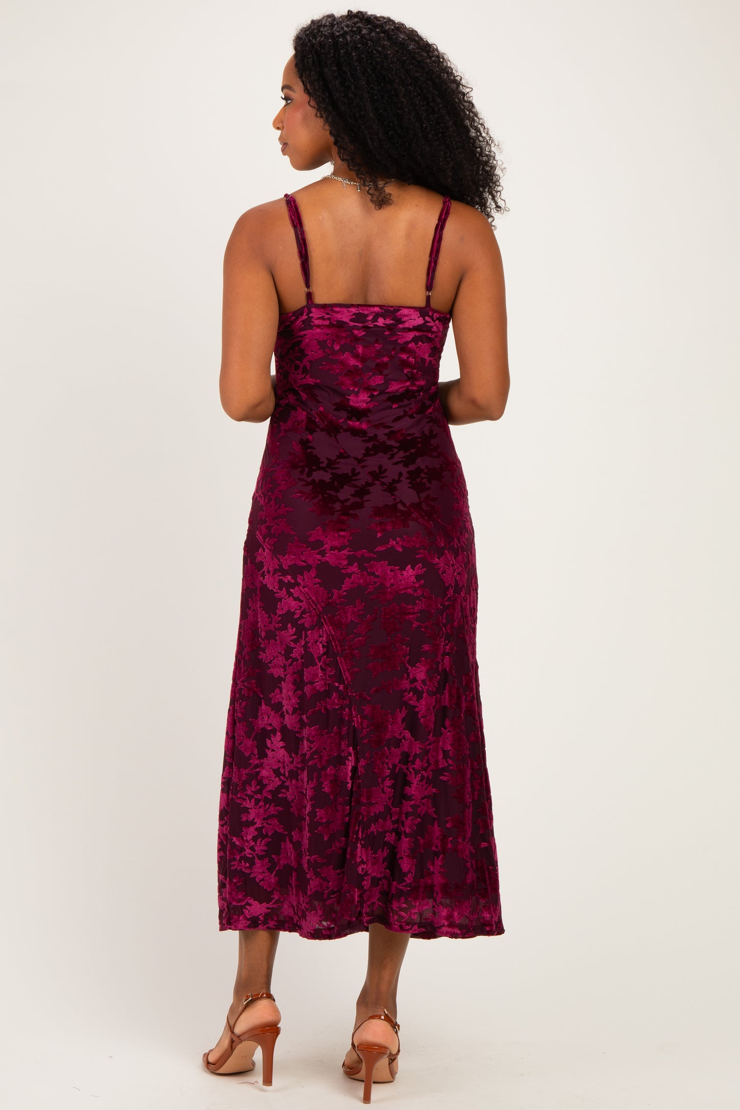 woman wearing a burgundy floral velvet midi dress with spaghetti straps, shown from the back