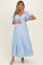 woman wearing a light blue maternity dress with flutter sleeves and a tie front, showing her baby bump
