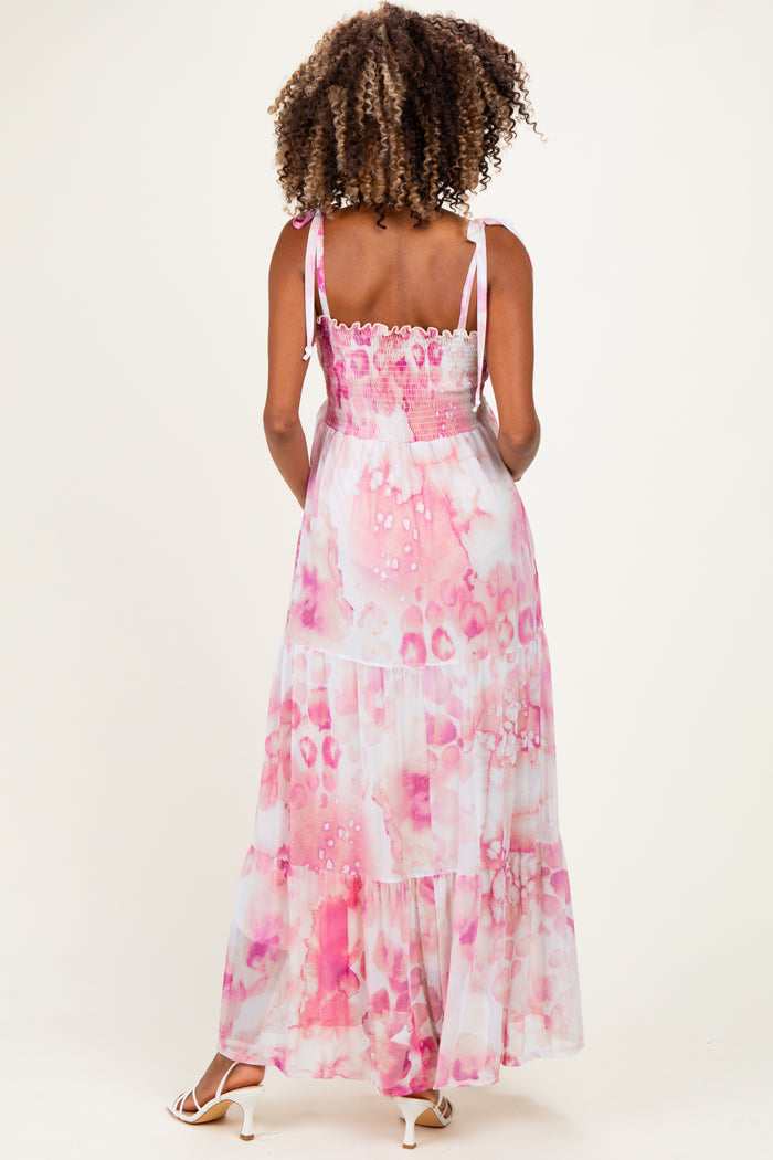 woman wearing a pink and white tie-dye maternity maxi dress with a smocked back and adjustable straps