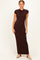 woman wearing a brown cap sleeve maxi dress standing against a light background