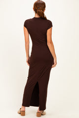 woman wearing a brown fitted maxi dress with a back slit and short sleeves, viewed from the back