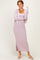 woman wearing a lavender ribbed maxi dress with a matching cardigan and white sandals, posing with one hand on her hip