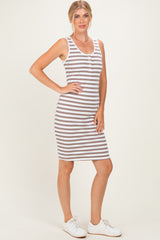 woman wearing a gray and white striped sleeveless midi dress with buttons and white sneakers