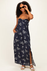 woman wearing a navy blue floral maxi dress with a strapless design and side slits