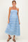 woman wearing a light blue floral maternity dress with a smocked bodice and spaghetti straps, holding her baby bump