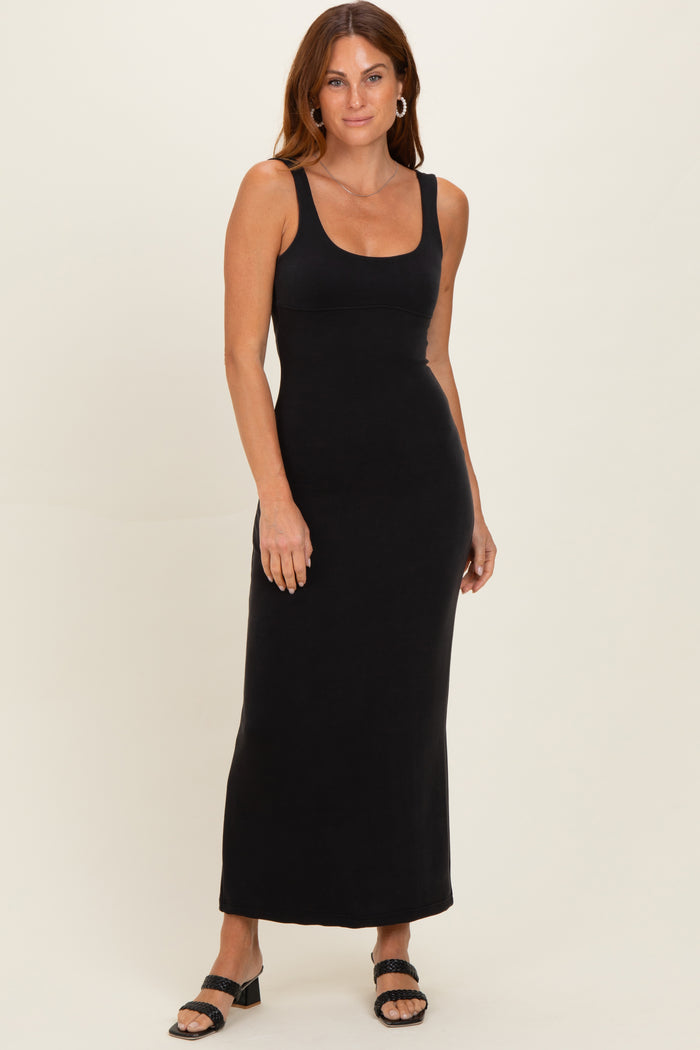 woman wearing a black sleeveless maxi dress with a scoop neckline and a fitted silhouette