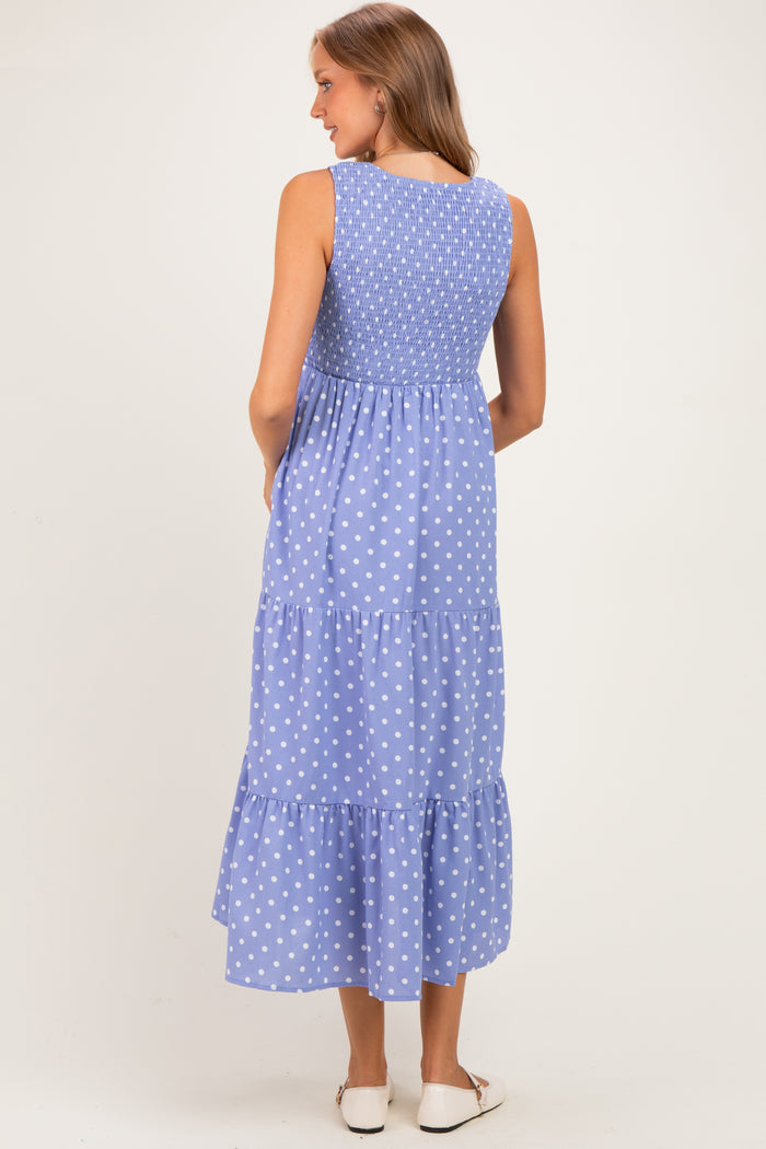 woman wearing a blue maternity maxi dress with white polka dots and a smocked back detail