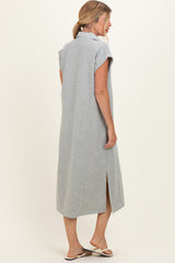woman wearing a gray maxi dress with short sleeves and side slits, seen from the back