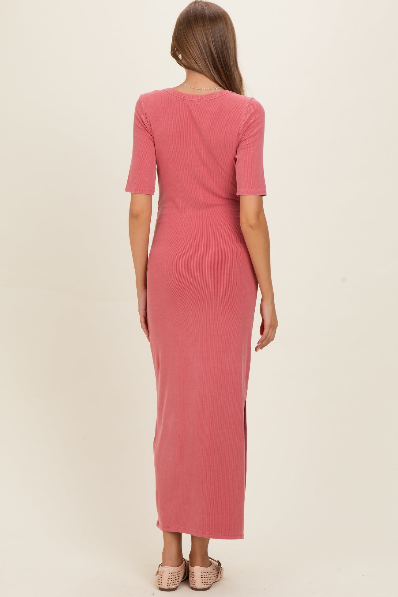 woman wearing a dusty rose maternity maxi dress with short sleeves and a back slit