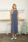 woman wearing a sleeveless long gray maxi dress and blue sneakers