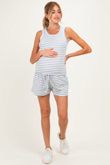 woman wearing a gray and light blue striped maternity tank top and matching shorts, holding her baby bump