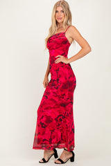 woman wearing a red floral maxi dress with a fitted silhouette and spaghetti straps, standing sideways