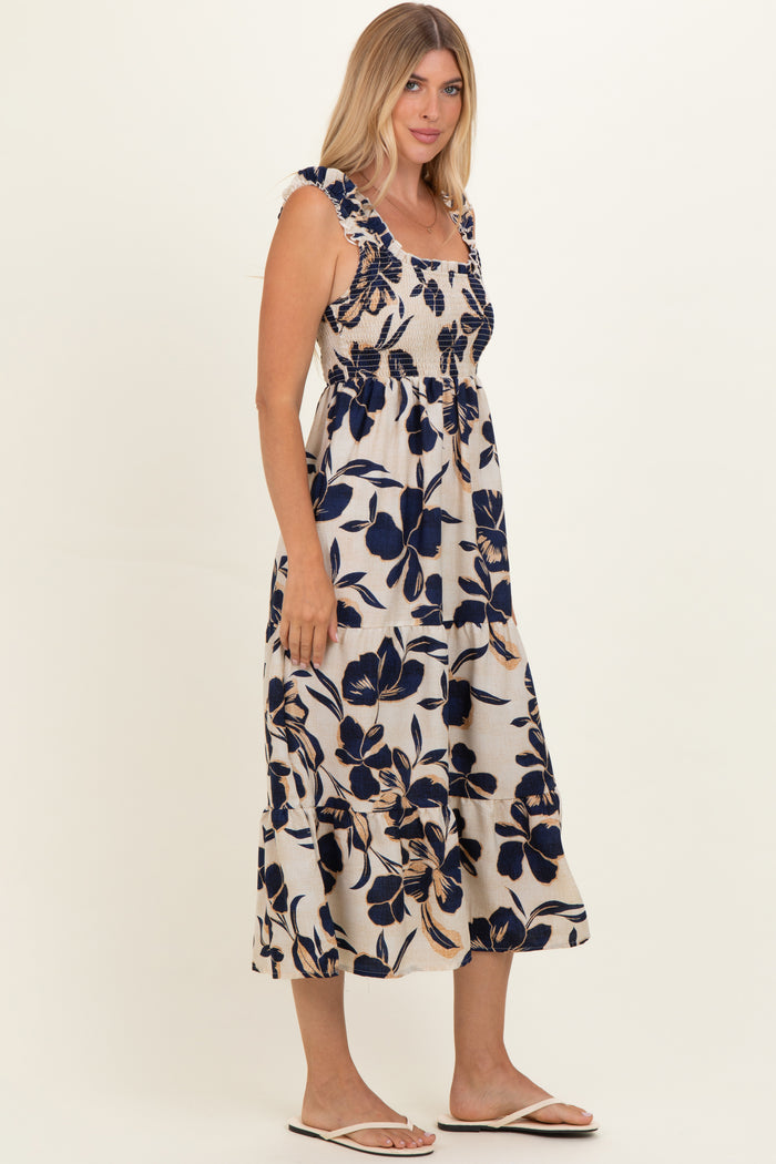 woman wearing a floral print maxi dress with blue and beige colors and ruffled straps