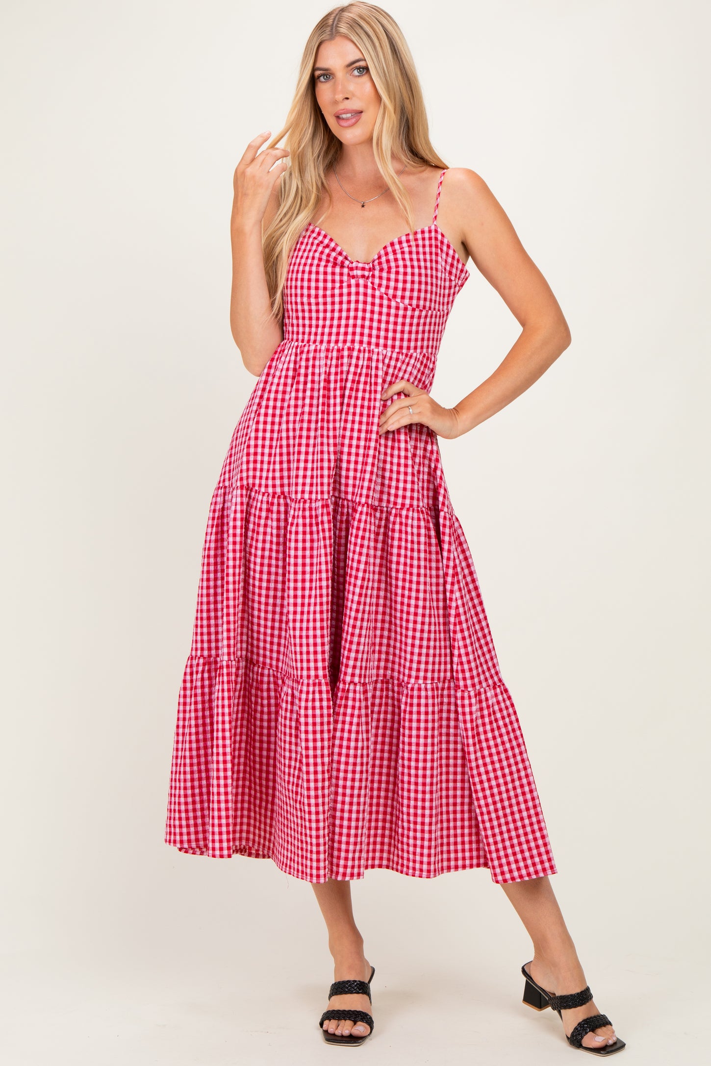 woman wearing a red and white gingham tiered maxi dress with thin straps and a v-neckline