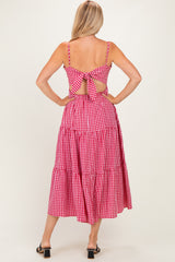 woman wearing a red and white gingham midi dress with a tie-back and tiered skirt, showing the back view