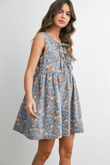 woman wearing a blue floral sleeveless dress with lace-up detail and a flared silhouette