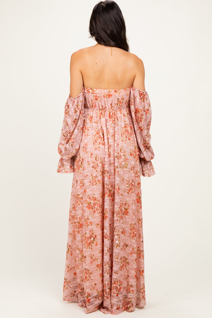 woman wearing a pink off-the-shoulder maxi dress with floral print and long puff sleeves, shown from the back