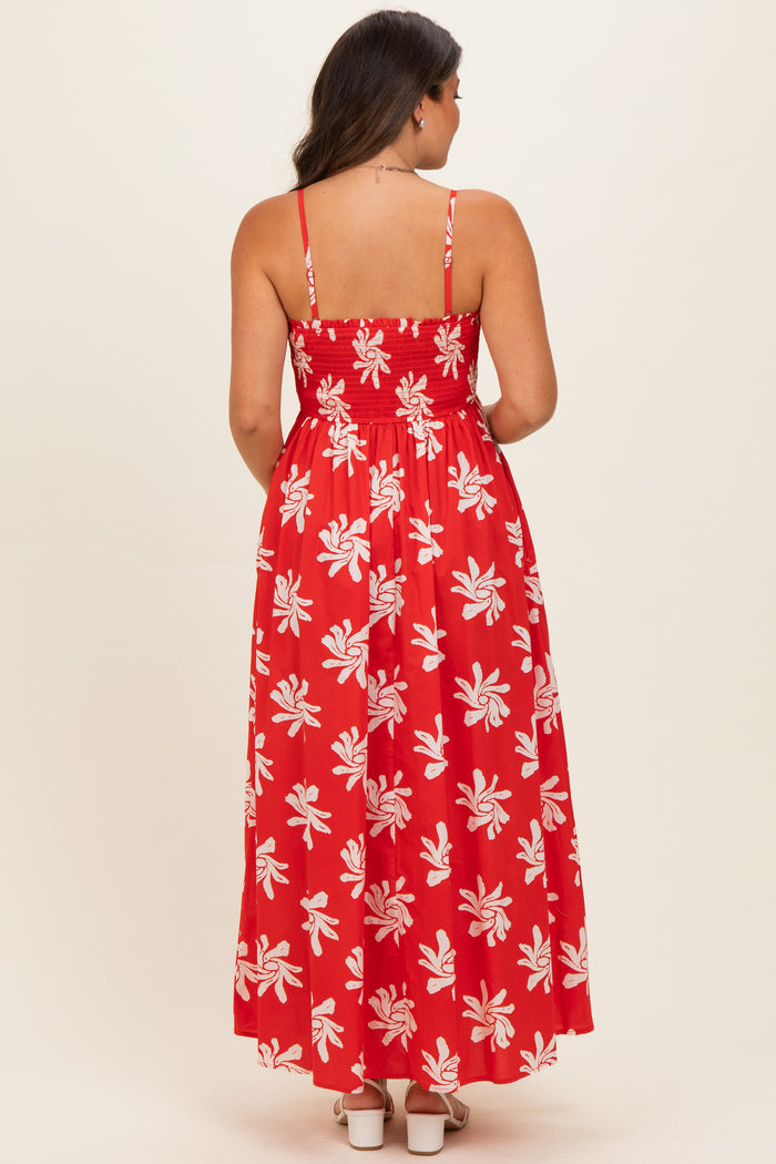 woman wearing a red maternity maxi dress with a floral pattern and back smocking detail