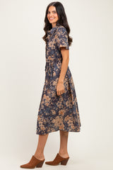 woman wearing a navy blue floral midi dress with short sleeves and a belted waist