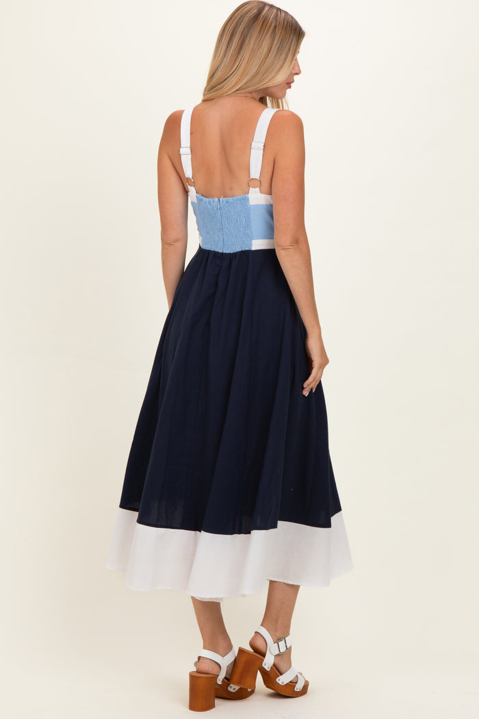 woman wearing a navy and white color-block midi dress with adjustable straps and a smocked back detail