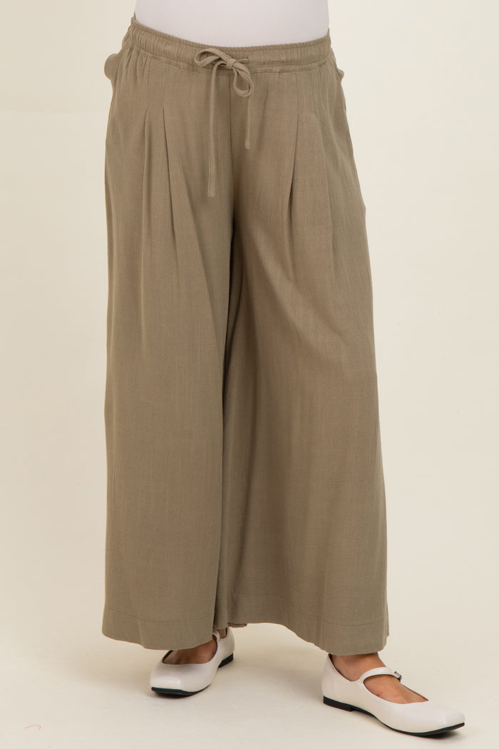 woman wearing olive green maternity wide-leg pants with a drawstring waist and pleated details