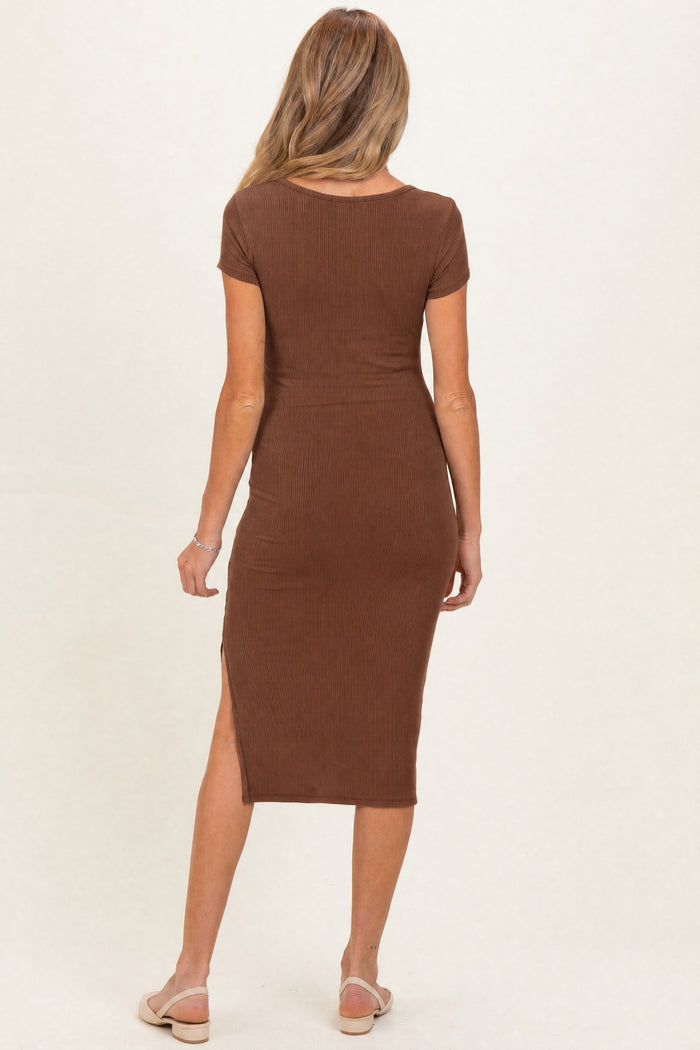 woman wearing a brown ribbed maternity dress with short sleeves and a side slit, showcasing her baby bump