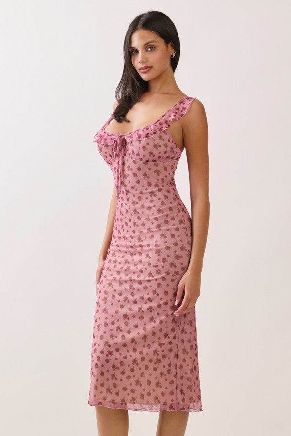 woman wearing a pink floral midi dress with a sweetheart neckline and ruffle details