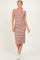 woman wearing a striped midi dress with a scoop neck and short sleeves, styled with white sneakers