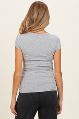 woman wearing a fitted gray maternity top, showing the back view with short sleeves and gathering at the sides