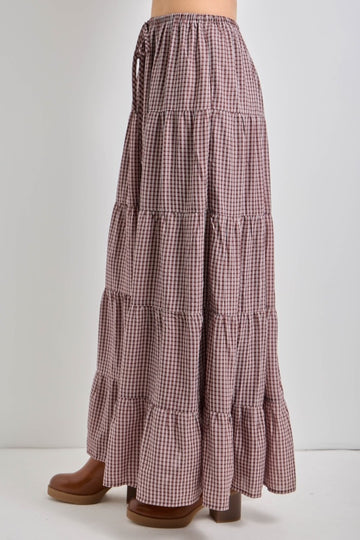 long tiered maxi skirt in a brown and white gingham pattern with an elastic waistband and side ties