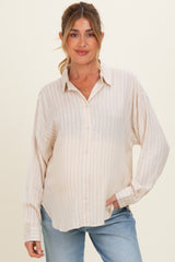 woman wearing a cream striped maternity button-up shirt and showing her baby bump
